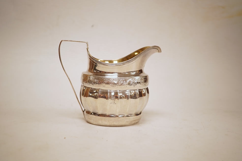A George III engraved silver helmet shaped cream jug, with fluted body, Soloman Hougham?, London, 1800, height 97mm, 4.5oz (repair).